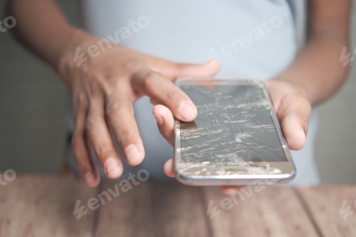 Preview: Close up of man hand holding broken smart phone.
