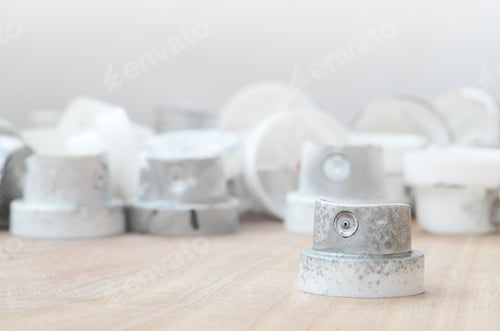 Preview: Several plastic nozzles from a paint sprayer that lie on a wooden surface