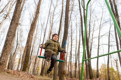 Preview: Young toddler boy swinging on a swing