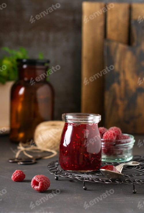 Preview: Raspberry jam in a glass jar with fresh raspberry berries on the old retro background.