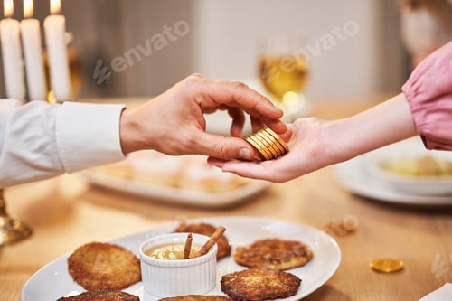 Preview: Hanukkah dinner. Focus on father giving coins to children