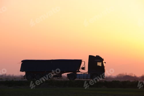 Preview: Semi-truck with tipping cargo trailer transporting sand from quarry driving on highway