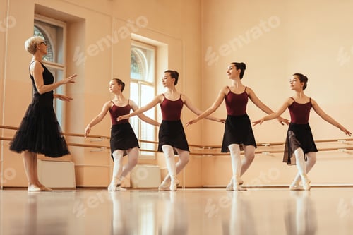 Preview: Female instructor holding ballet dance lesson to group of ballerinas.