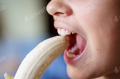 Preview: Crop girl with mouth open eating fresh peeled banana