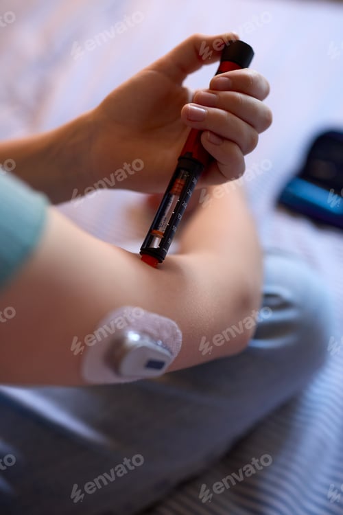 Preview: Close Up Of Diabetic Girl On Bed In At Home Using Insulin Pen To Measure To Check Blood Sugar Level