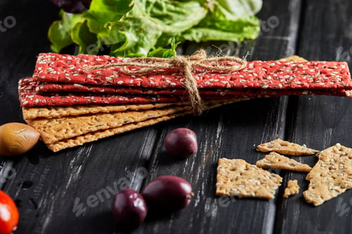 Preview: Beetroot and rye flour crackers with vegetables for making snacks on a black background.