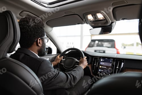 Preview: Businessman buying car at dealership sitting inside vehicle