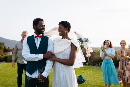 Preview: Happy african american couple holding hands during wedding