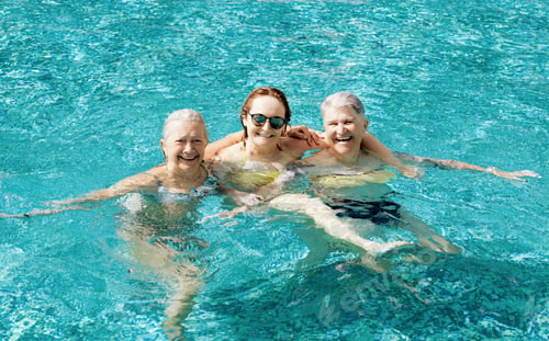Preview: Three active mature senior caucasian friends women have fun in outdoor swimming pool