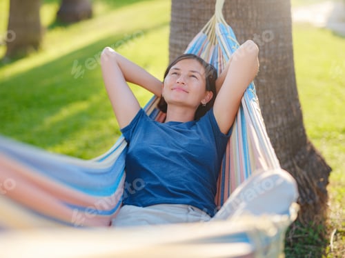 Preview: young beautiful lady posing while lying on hammock,