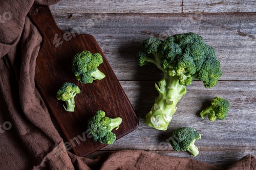 Preview: Fresh broccoli with wooden cutting board on old wooden table