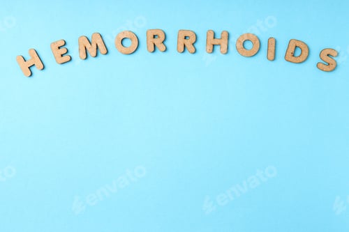 Preview: Concept of hemorrhoids with wooden letters on blue background