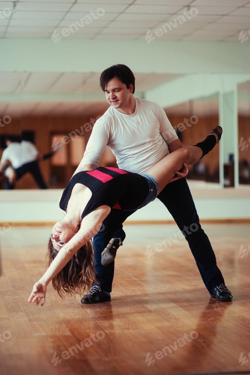 Preview: young couple dancing on the roof of a tall building