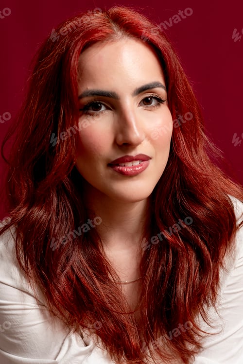 Preview: Confident woman looking at the camera and smiling while posing against a red isolated background.
