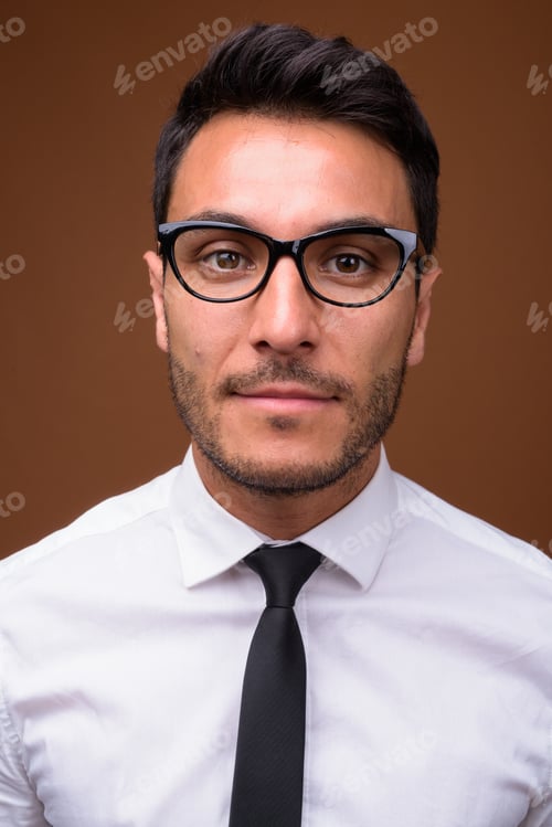 Preview: Young handsome Hispanic businessman against brown background
