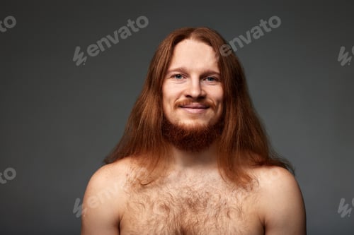 Preview: Close-up studio portrait of a young red-haired man with long straight hair, mustache and beard on a