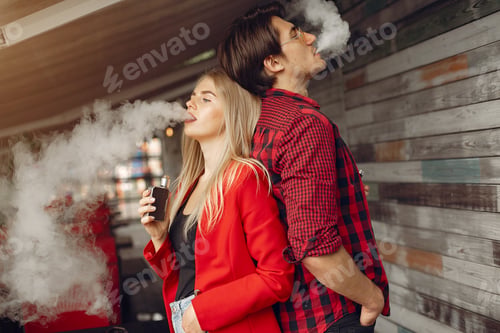 Preview: Stylish young couple with vape in a city