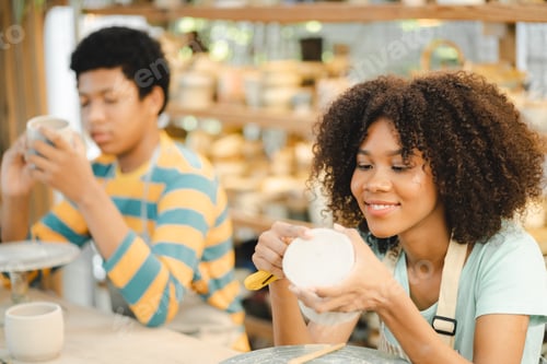 Preview: Creative afro American young artist molding clay on pottery wheel, Workshop in ceramic studio