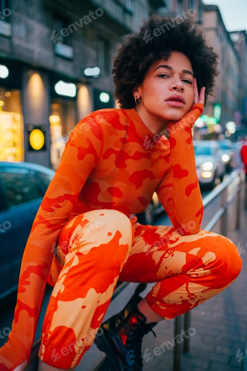 Preview: Stylish afro black young woman posing sitting outdoors fashionable cool attitude