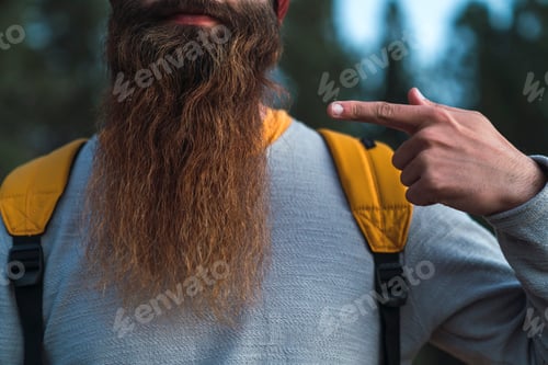 Preview: Close-up of man wearing backpack pointing at his beard