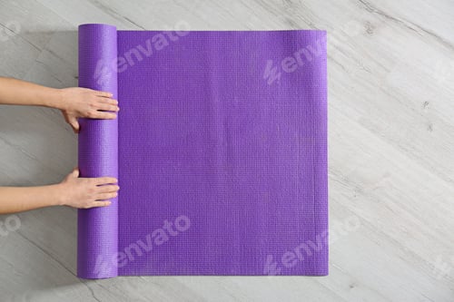 Preview: Woman rolling yoga mat on floor, top view. Space for text