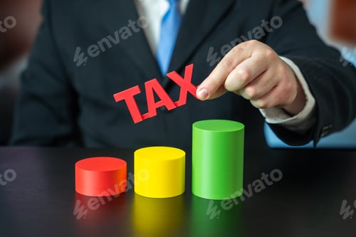 Preview: A businessman holds a sign Tax over a growth chart. Concept of increasing taxes on business