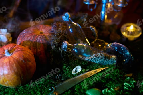 Preview: Items are placed on a table for a spooky party. Pumpkins, glass bottles