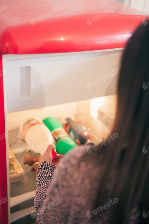 Preview: Close-Up One Young Woman In Small Apartment Pulling Food Out Of Fridge.
