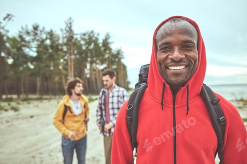 Preview: Best Outing. Waist Up Portrait Of Smile Man Standing At The Sea Shore While His Friends Talking On