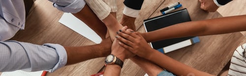 Preview: Multicultural team. Top view of business people holding hands together while sitting in the office