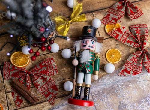 Preview: Top view of a wooden nutcracker toy on the table with Christmas decorations