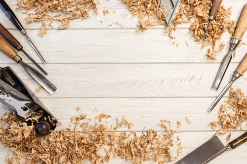 Preview: Flat lay of traditional carpenter tools and wood shavings on white wooden planks with Copy space