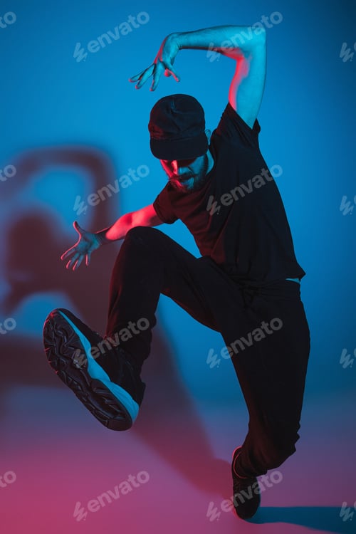 Preview: The silhouette of one hip hop male break dancer dancing on colorful background