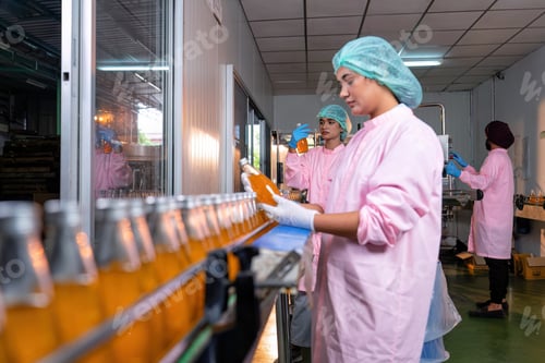 Preview: Beverage worker in drink factory stand working near drinking bottle conveyor production line