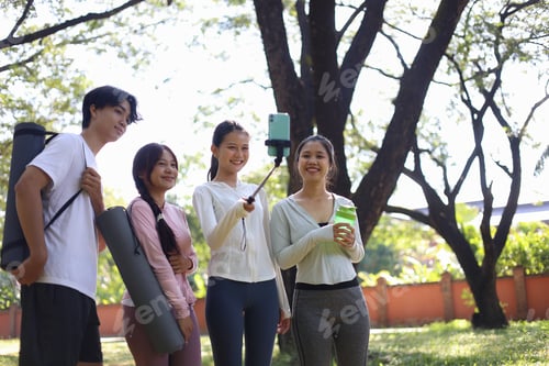 Preview: Friends taking a group selfie in the park after a workout.