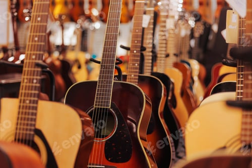 Preview: Many different acoustic guitars hanging on wall of music shop. Close up.