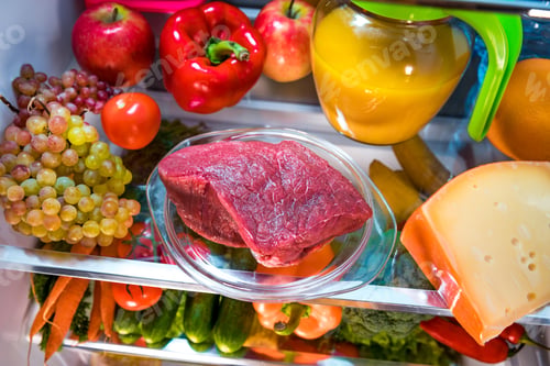 Preview: Fresh raw meat on a shelf open refrigerator