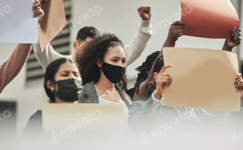 Preview: Low angle shot of a group of people holding signs while taking part in a political rally