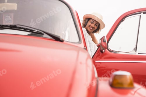 Preview: couple of women friends enjoying leisure activity with a red vintage retro car