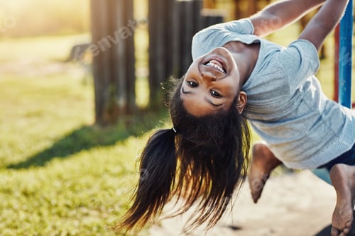 Preview: Cropped portrait of an adorable little girl playing on a merry-go-round at the park