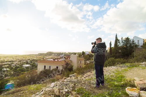 Preview: Traveler photographer with digital camera on top of the mountain