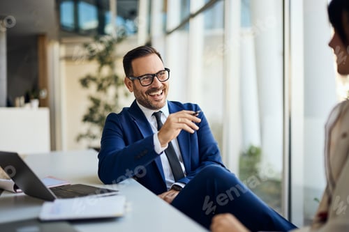 Preview: Professional Businessman Engaging in Friendly Conversation During Office Meeting