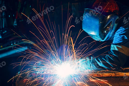 Preview: Welder welding metal construction on factory. Long traces of sparks