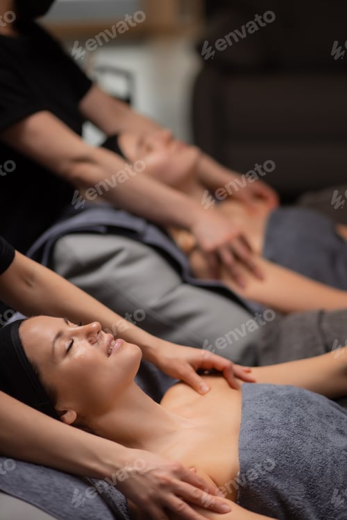 Preview: professional beautician making face massage for a woman in salon