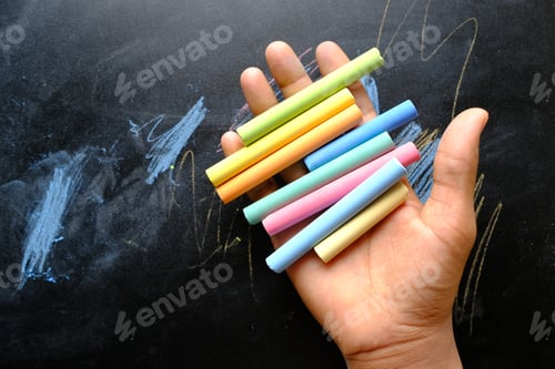 Preview: child holding many colorful chalk top view
