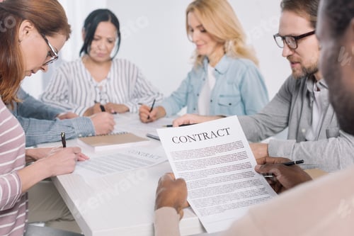Preview: cropped shot of african american man holding contract and people taking notes together