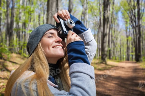 Preview: Woman in park taking photos with retro film camera