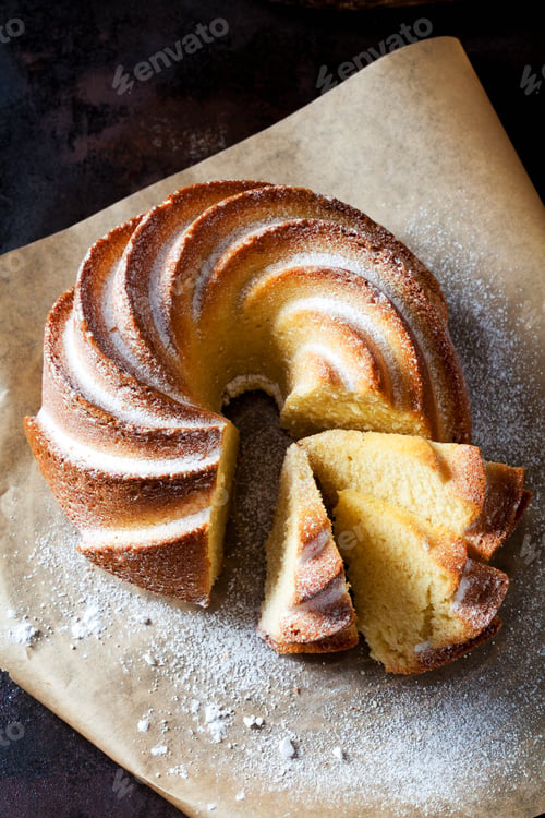 Preview: Sliced Gugelhupf sprinkled with icing sugar on parchment paper