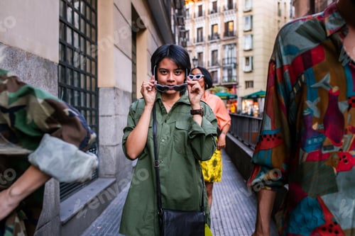 Preview: Stylish Asian woman walking amidst friends