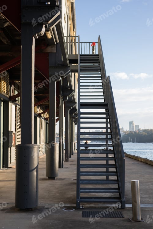 Dock Stairs Lead to City View on Sunny Day